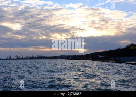 Coucher de soleil sur la mer d'azov avec vue sur Port Marioupol, Ukraine. Banque D'Images