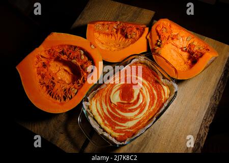 Gâteau au fromage à la tarte à la citrouille maison avec un morceau de citrouille. Dessert orange. Image verticale. Vue de dessus. arrière-plan en bois. Banque D'Images