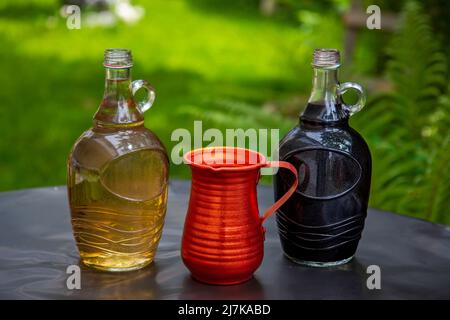 Trois bouteilles de différents types de vin sur la table dans la nature Banque D'Images