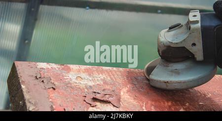 un homme meule une planche. Élimination de l'ancienne peinture des panneaux. Travail de menuiserie. Concentration sélective Banque D'Images