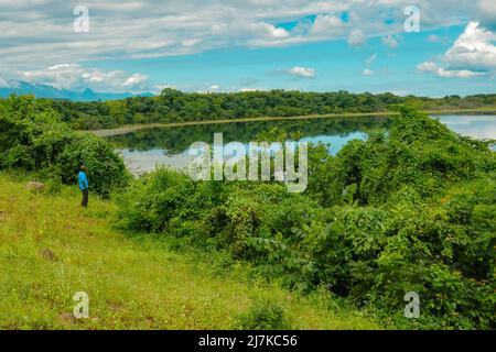 Homme à un point de vue panoramique au lac Ikapu carter à Mbeya, Tanzanie Banque D'Images