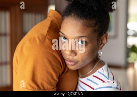 Portrait en gros plan d'une jeune femme afro-américaine confiante qui embrasse un petit ami amoureux chez elle Banque D'Images