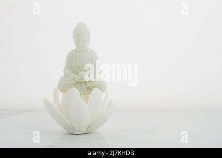 Vesak, Wesak, anniversaire de Bouddha. Statue de Bouddha avec lotus sur fond blanc. Rituel spa. Santé mentale et méditation. Banque D'Images