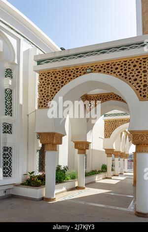 Long chemin vide entre colonnes avec éléments ornementaux et passages voûtés de la mosquée historique située sur la rue ensoleillée de la ville Banque D'Images