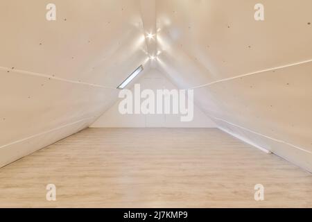 Intérieur d'une spacieuse chambre lumineuse mansardée avec des murs blancs et sans mobilier dans la journée à la maison Banque D'Images