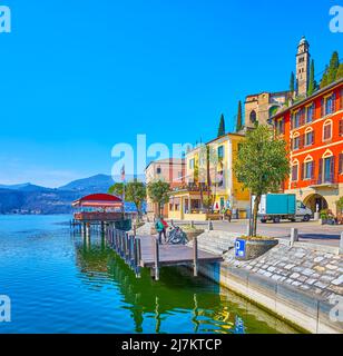 Les maisons pittoresques et colorées du village de Morcote depuis la rive du lac de Lugano avec vue sur le grand clocher de l'église Santa Maria del Sasso, domina Banque D'Images