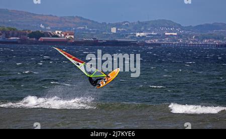 Longniddry, East Lothian, Écosse, Royaume-Uni. 10th mai 2022. Matin venteux sur la côte pour les amateurs de sports nautiques et les personnes qui font de l'exercice. Température 13 degrés, vent 22 km/h avec des rafales potentielles de 46 km/h. Planche à voile, Ross prend de l'air sur le Firth of Forth. Crédit : Arch White/alamy Live News Banque D'Images