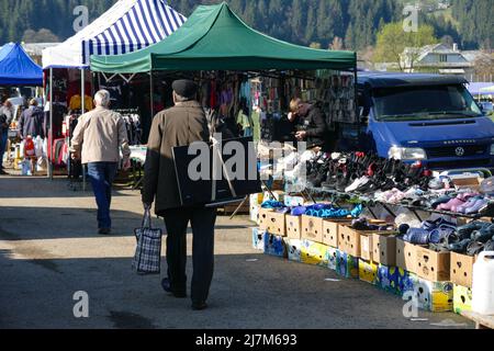 Non exclusif: VERKHOVYNA, UKRAINE - 7 MAI 2022 - Un homme porte un téléviseur sur son dos entre les étals d'un marché improvisé dans le village de Verkhovyna Banque D'Images