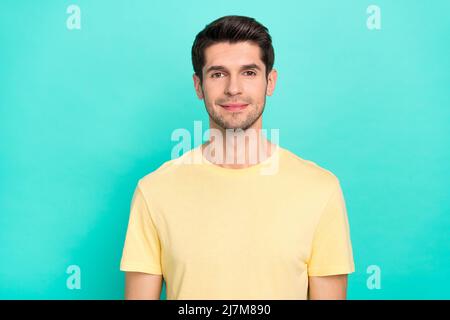 Photo de beau brunet millennium gars porter un t-shirt jaune isolé sur fond turquoise couleur Banque D'Images