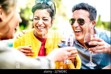 Des amis authentiques qui boivent du vin rouge à la maison pic nic Party - des personnes de l'âge mixte se sont amusés ensemble au restaurant bar de la cave de vinification le happy hour Banque D'Images