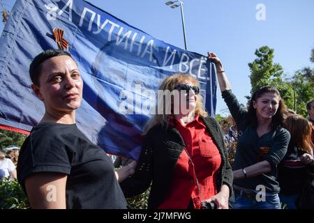 Athènes, Grèce. 9th mai 2022. Les gens détiennent un drapeau représentant Vladimir Poutine lors d'un événement commémoratif du jour de la victoire. Les Russes vivant en Grèce ont tenu un événement en mémoire du jour de la victoire de l'armée soviétique. (Credit image: © Dimitris Aspiotis/Pacific Press via ZUMA Press Wire) Banque D'Images