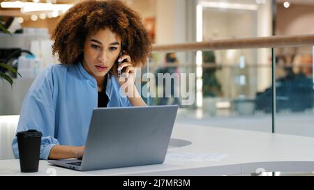 African american girl étudiante curly business femme multitâche femme gestionnaire travailleur consultant parler au téléphone dactylographiant sur des papiers d'écriture d'ordinateur portable Banque D'Images