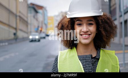Femme portrait profession gros plan afro-américaine femme fille avec cheveux bouclés génie civil professionnel portant un casque de sécurité debout Banque D'Images