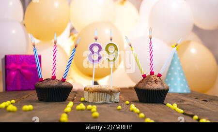 Belle carte d'anniversaire pour une fille avec un cupcake sur le fond des ballons. Joyeux anniversaire fille, boîte cadeau sur le fond de bougies allumées. Banque D'Images