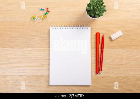Table de travail avec clavier et bloc-notes, stylo, crayon et usine dans le bureau à domicile. Vue du dessus Banque D'Images
