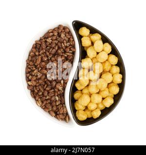 Céréales séchées pour le petit déjeuner dans des assiettes Yin-Yang isolées sur fond blanc, gros plan, saine alimentation Banque D'Images