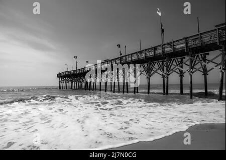 BW Pier sur l'océan Atlantique avec des vagues qui s'écrasant sur la plage - Noir et blanc Banque D'Images