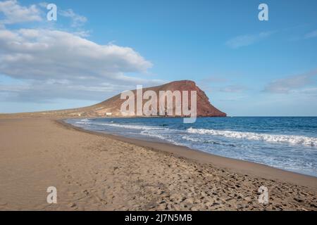 Paysage côtier solitaire avec une grande plage vide connue localement sous le nom de Playa de la Tejita et le cône volcanique, Montana Roja, Tenerife, Espagne Banque D'Images