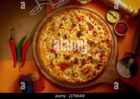 pizza au poulet au barbecue avec sauce tomate et mayonnaise isolée sur un plateau en bois, vue sur la cuisine italienne sur fond de bois Banque D'Images