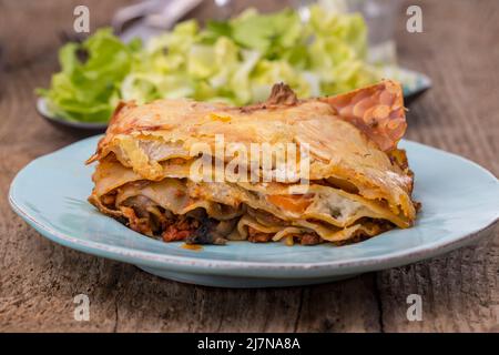 lasagnes avec salade sur bois sombre Banque D'Images