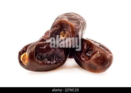 Les dates sont isolées.Les dates se déversent d'une tasse en forme de coeur sur un fond blanc gros plan.Fruits secs Banque D'Images