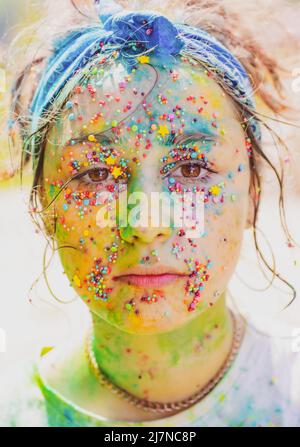 Jeune femme avec art créatif visage couleur. Holi coloré éclabousse. Banque D'Images
