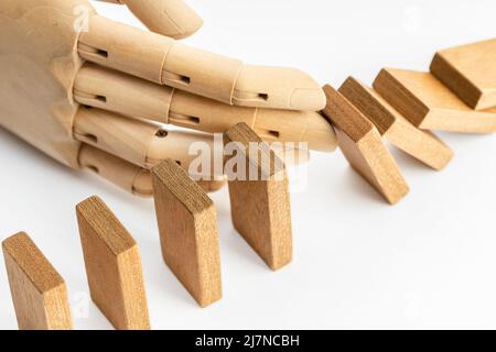 Bois arrêt de main chute en bois effet Dominoes. Concept de solution et de stratégie de gestion des risques métier Banque D'Images