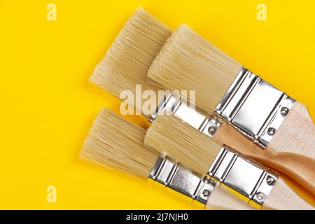 Jeu de différents pinceaux propres sur fond jaune Banque D'Images