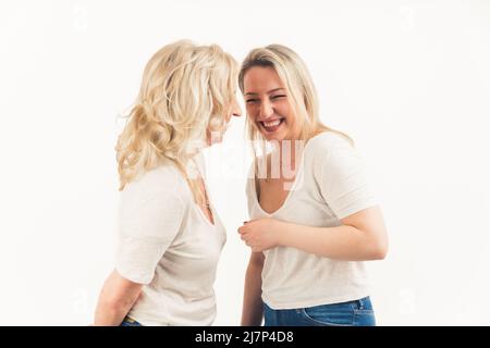 Une mère aînée et une fille adulte débordés de joie s'amusent ensemble, une maman mûre heureuse et une jeune fille millénaire grognée dans un studio, se sentent excités et optimistes. Photo de haute qualité Banque D'Images