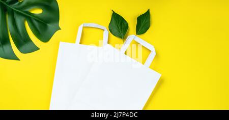 Ensemble de plusieurs sacs en papier jetables pour les aliments à emporter, les cadeaux et les maquettes.sacs en papier écologiques sur fond jaune.Sac à provisions en papier recyclé Banque D'Images