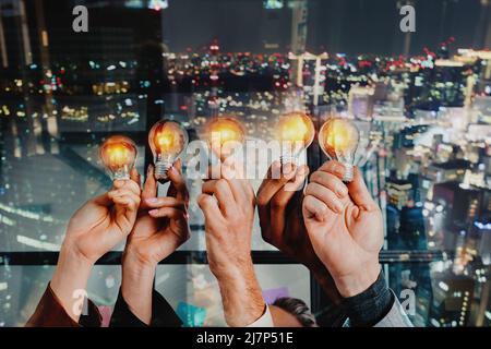 Travail d'équipe et remue-méninges avec des hommes d'affaires qui partagent une idée avec une lampe Banque D'Images