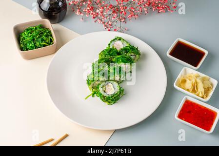 petits pains à sushis japonais avec salade de crevettes et de chuka sur une ba colorée Banque D'Images