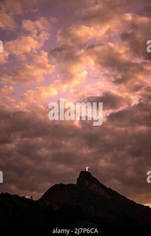 Belle vue sur les nuages orange au-dessus de la statue du Christ Rédempteur Banque D'Images