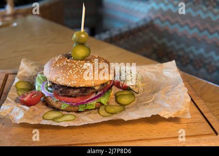 Un hamburger avec veau, feuilles de laitue, tomates et cornichons Banque D'Images