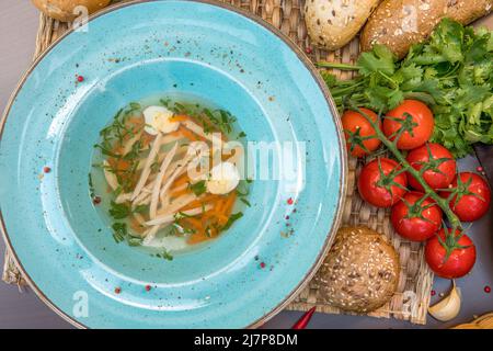 Bouillon de poulet avec pâtes faites maison, carottes, filets et œufs de caille Banque D'Images