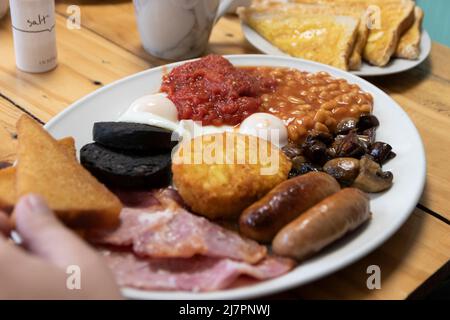 Un petit déjeuner anglais complet - également appelé « friture » - composé d'œufs, saucisses, bacon, tomates, champignons, haricots, pain frit, pot de haschbruns Banque D'Images