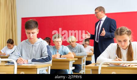 Les adolescents qui travaillent en classe pendant la leçon Banque D'Images