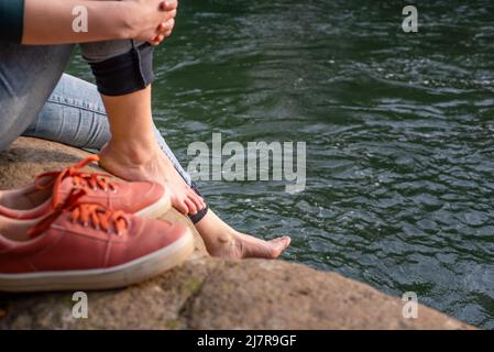 Gros plan des pieds et des chaussures de femme près de la rivière Banque D'Images