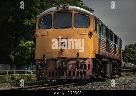 La vue avant de la locomotive diesel électrique est garée sur les anciennes voies de chemin de fer. Le train jaune passager vide, mise au point sélective. Banque D'Images