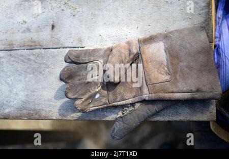 Rosengarten, Allemagne. 21st avril 2022. Des gants sont disposés sur une table dans le musée en plein air du Kiekeberg. Le poêle était le centre de la vie familiale, surtout dans les temps précédents - comme source de chauffage et plus tard comme objet d'utilité et de prestige. Dans le musée en plein air du Kiekeberg, une exposition montre le développement de la cuisine. Credit: Philipp Schulze/dpa/Alamy Live News Banque D'Images