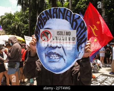 Un manifestant tient une coupure de l'aspirant présidentiel Ferdinand 'Bongbong' Marcos pendant la manifestation. Un groupe de jeunes mécontents qui approuvent l'aspirant présidentiel Leonor 'Leni' Robredo a organisé une manifestation au siège de la Commission électorale (COMELEC) et à Liwasang Bonifacio à Manille. Comme Marcos Jr. A montré une avance significative des votes dans un décompte partiel et non officiel basé sur 61,05 % des résultats des élections montrant Marcos avance avec 20 millions de votes contre son rival le plus proche, le vice-président et ancien avocat des droits de l'homme Leni Robredo avec 9,5 millions de votes à partir de lundi soir. Banque D'Images