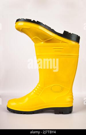 Bottes en caoutchouc jaune robustes et étanches isolées sur fond blanc Banque D'Images