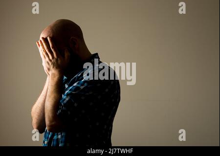 PHOTO POSÉE PAR LE MODÈLE photo du dossier datée du 09/03/15 d'un homme montrant des signes de dépression. Une enquête a révélé que près d'une personne sur cinq (18 %) avait perdu le sommeil en raison de la hausse des prix ces derniers mois. Et un quart (25 %) ont déclaré que la gestion de leurs finances est la principale cause de stress en ce moment, selon la Banque Shawbrook. Date de publication : le mercredi 11 mai 2022. Banque D'Images