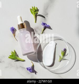 sérum anti-âge en bouteille de verre et nuance de crème pour le visage. produit cosmétique sans marque sur les boîtes de petri de laboratoire. concept de cosmétologie. professionnel de la santé Banque D'Images