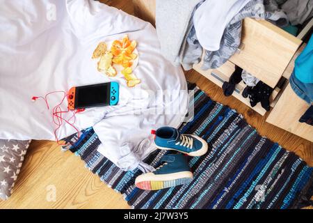 Mess dans la chambre d'un adolescent, vue de dessus. Choses éparses, décodeur sur le sol Banque D'Images