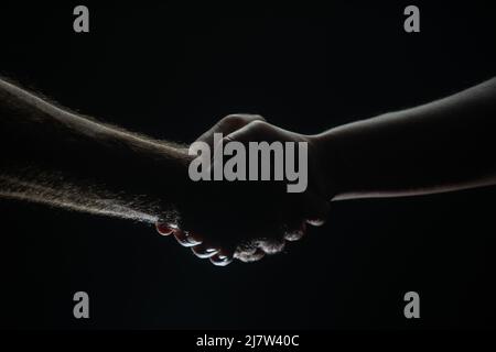 Poignée de main entre les deux partenaires, accord. Sauvetage des mains de sexe masculin. Poignée de main amicale, salutation des amis, amitié. Sauvetage, geste d'aide ou mains Banque D'Images