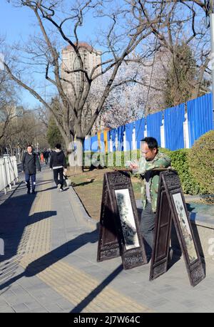 Un artiste chinois vendant ses peintures dans la rue à Beijing, en Chine. Banque D'Images