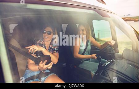 Vue avant à travers le pare-brise des femmes voyageant dans une camionnette de camping Banque D'Images