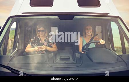 Vue avant à travers le pare-brise des femmes voyageant dans une camionnette de camping Banque D'Images