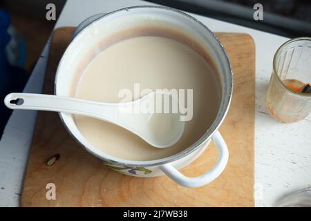 Pâte à crêpes dans une petite casserole pour faire des crêpes à la noix de coco et à la banane. Banque D'Images